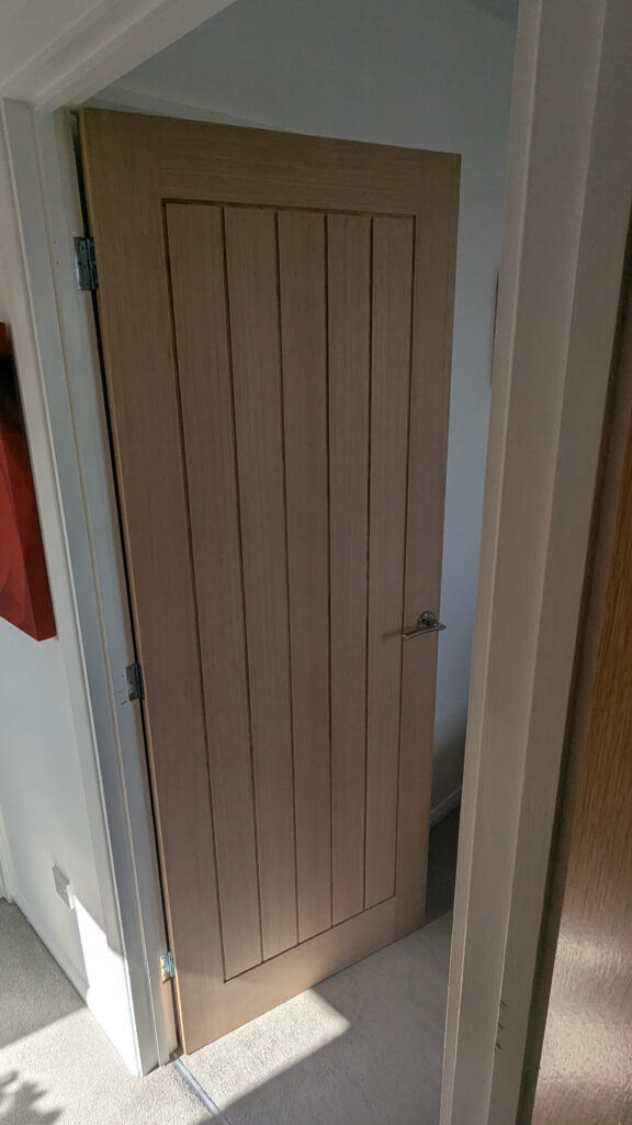 Unfinished cottage oak door installed with hardware