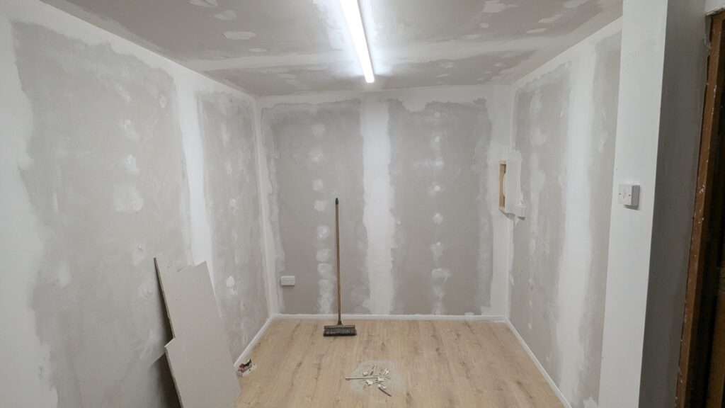 Fully tape, joined garage conversion with a light oak laminate floor